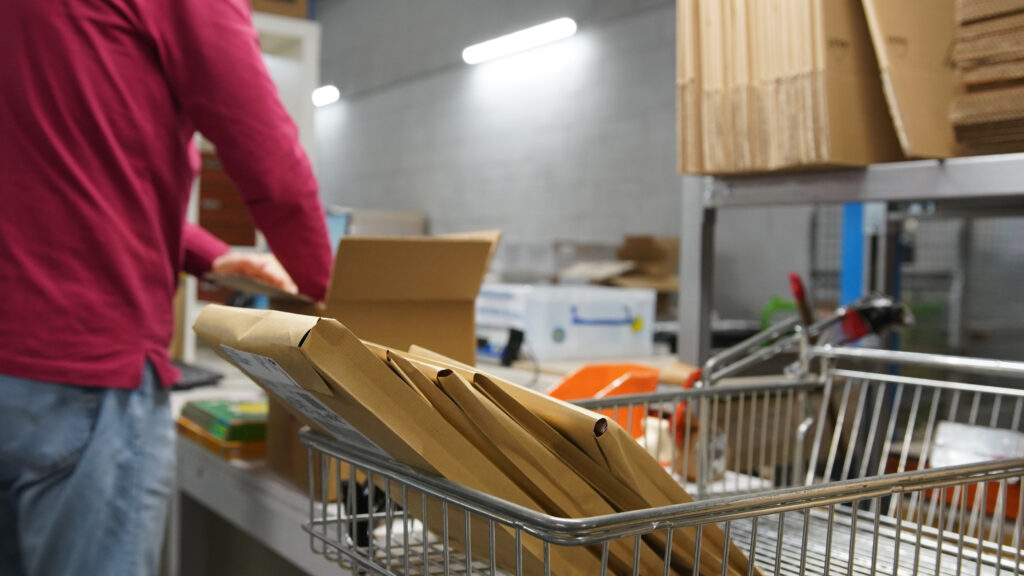 Opérateur en train de préparer des colis kraft dans l'entrepôt logistique EA Papyrus Lyon 8
