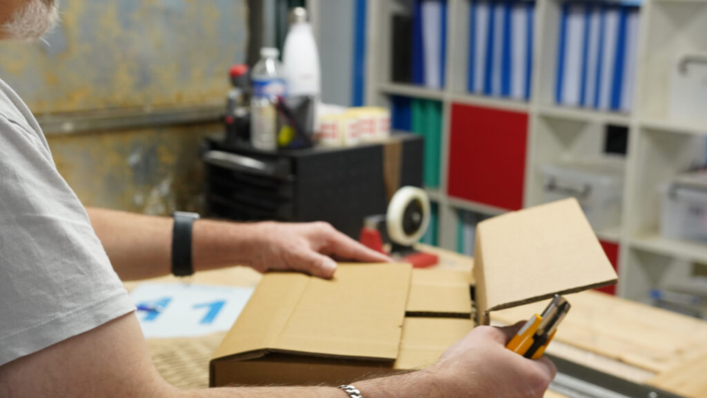 Préparation de commandes et conditionnement carton par un opérateur logistique à Lyon